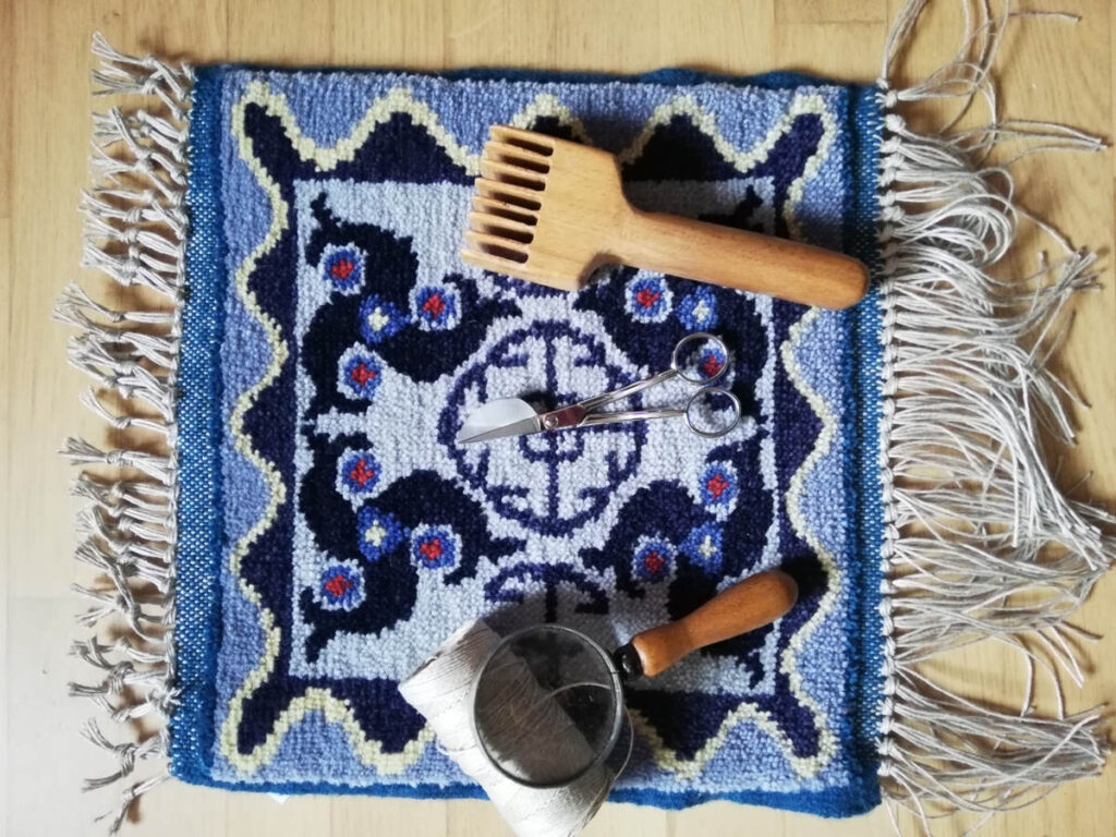 kleiner Teppich mit Dreifischmotiv und Werkzeug